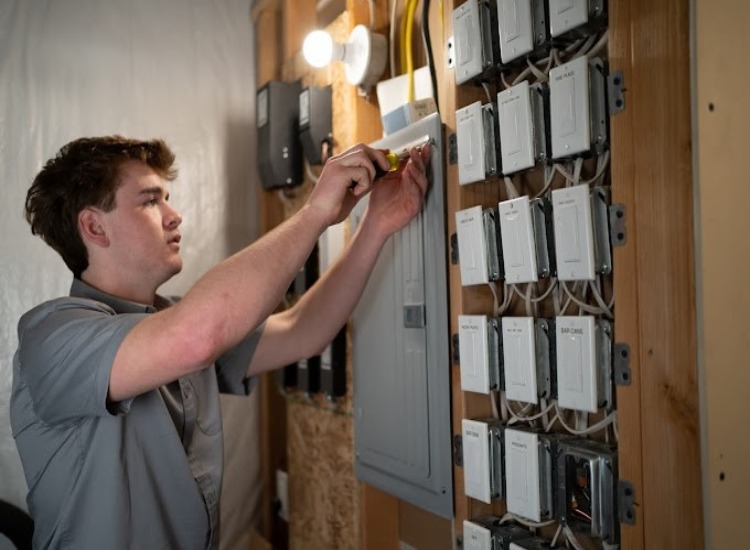 An electrician performing preventative electrical maintenance in a Grimes, Iowa home.