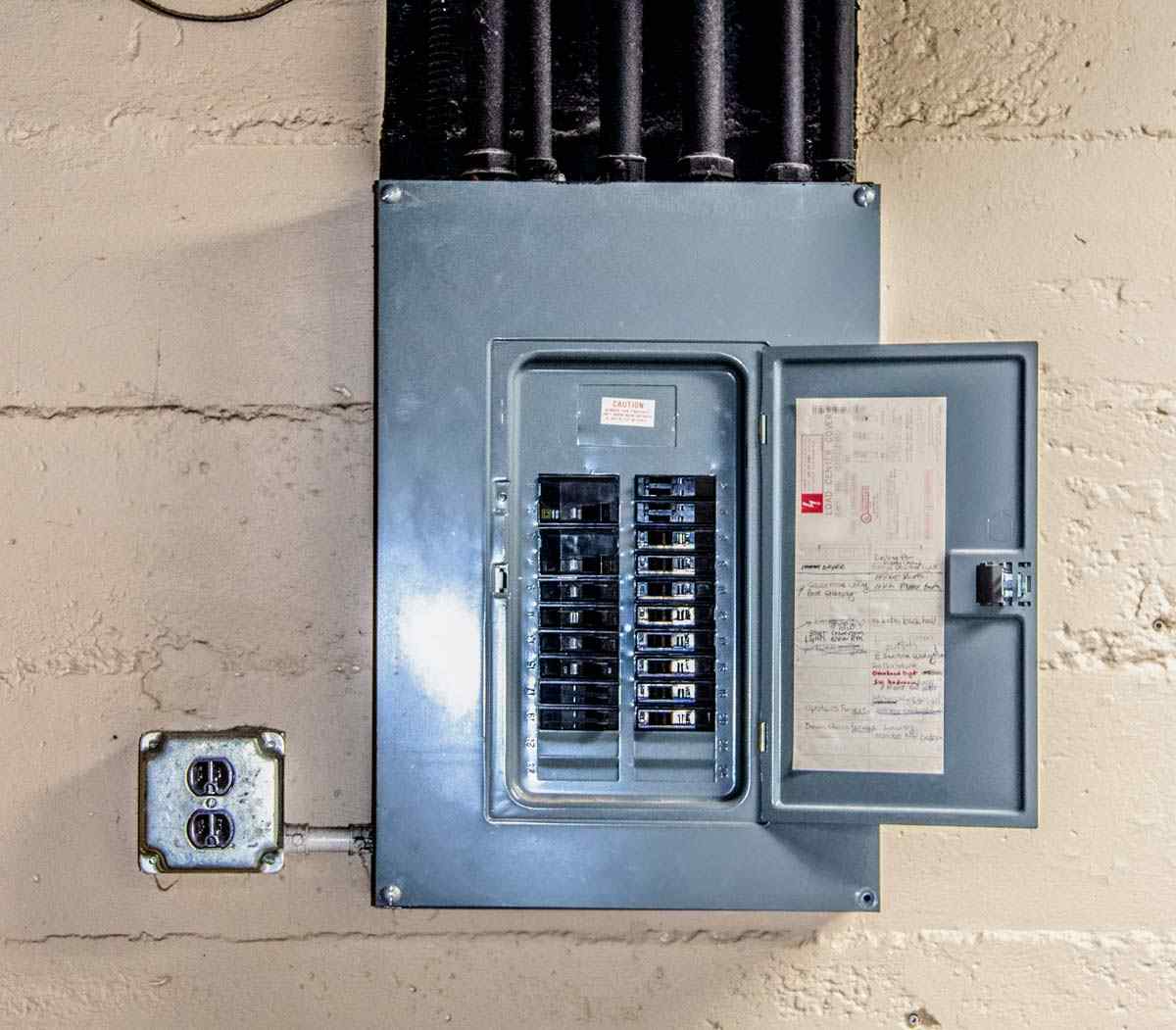 Metal electrical panel with a switch and wires, showcasing the home’s electrical system in Grimes, IA.