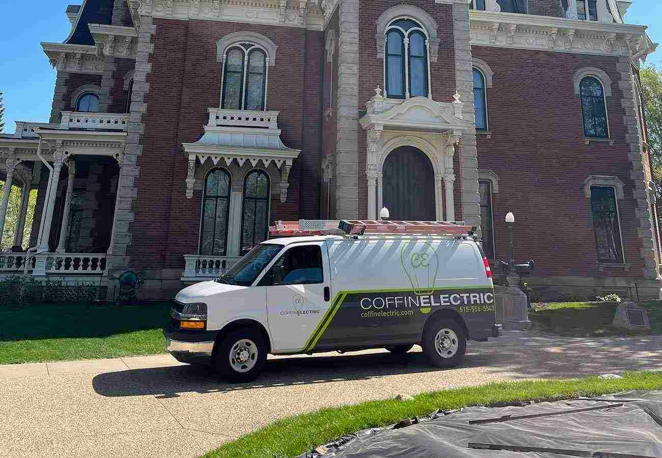 A white van from Coffin Electric parked in front of a large mansion in Grimes, IA.