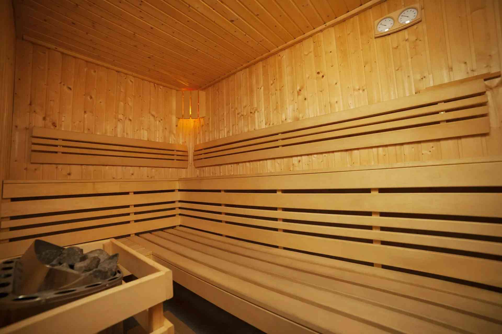 Relaxing sauna room with wooden walls and benches, designed for wellness and comfort in Grimes, IA.